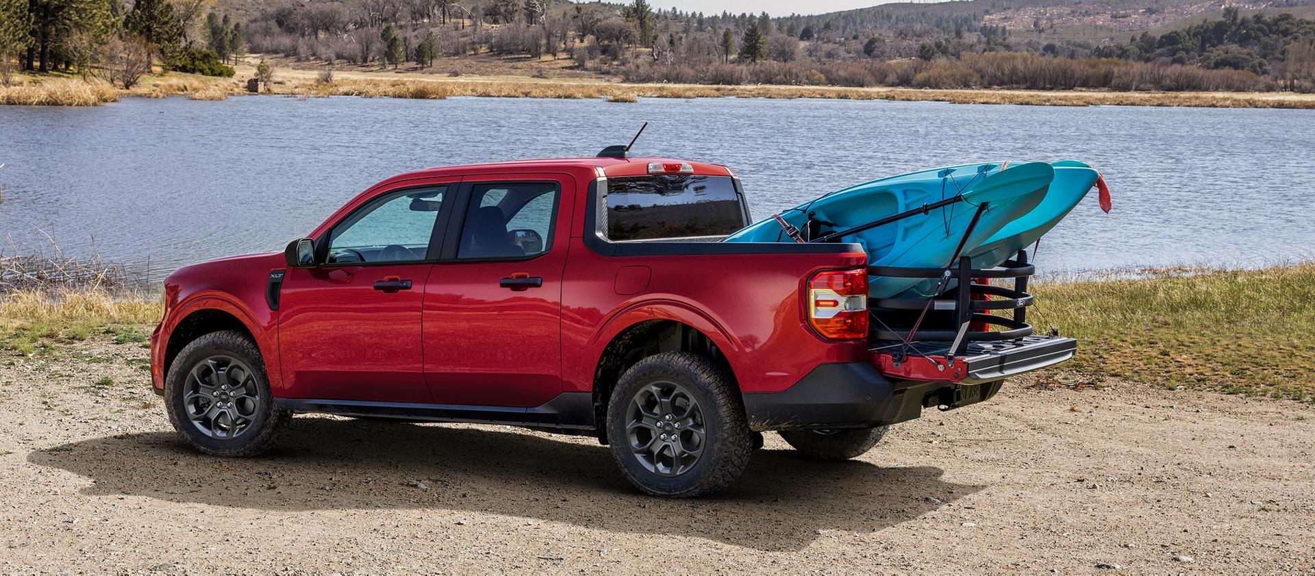 2026 Ford Maverick® Lariat® parked near a lake with two kayaks in the bed. Optional equipment shown.