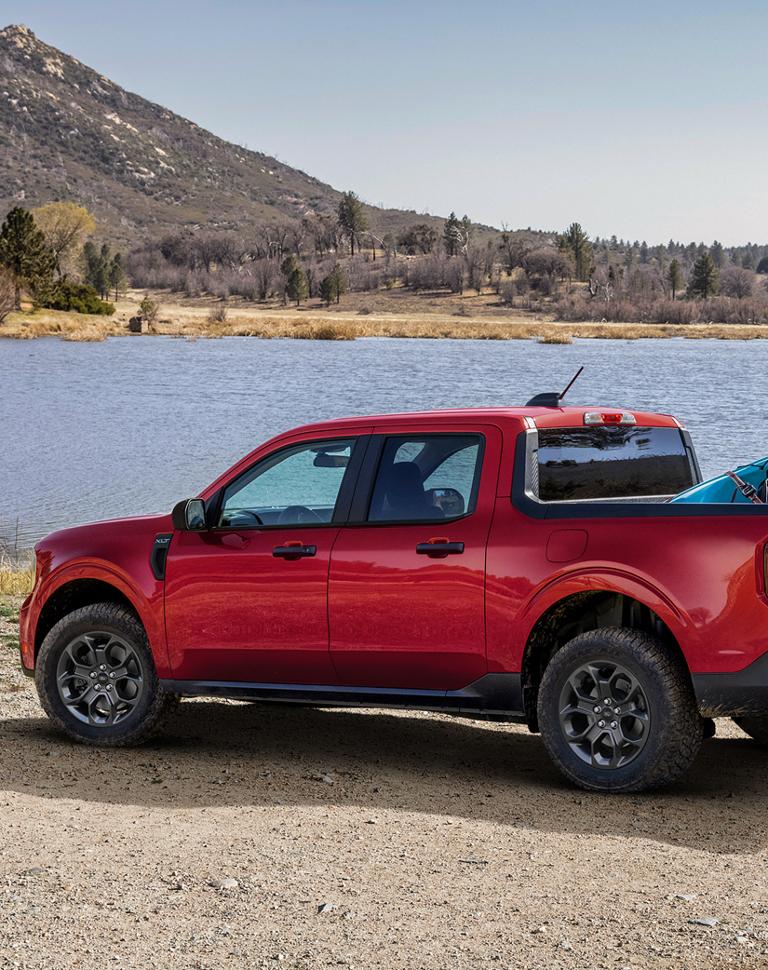 2026 Ford Maverick® Lariat® parked near a lake with two kayaks in the bed. Optional equipment shown.