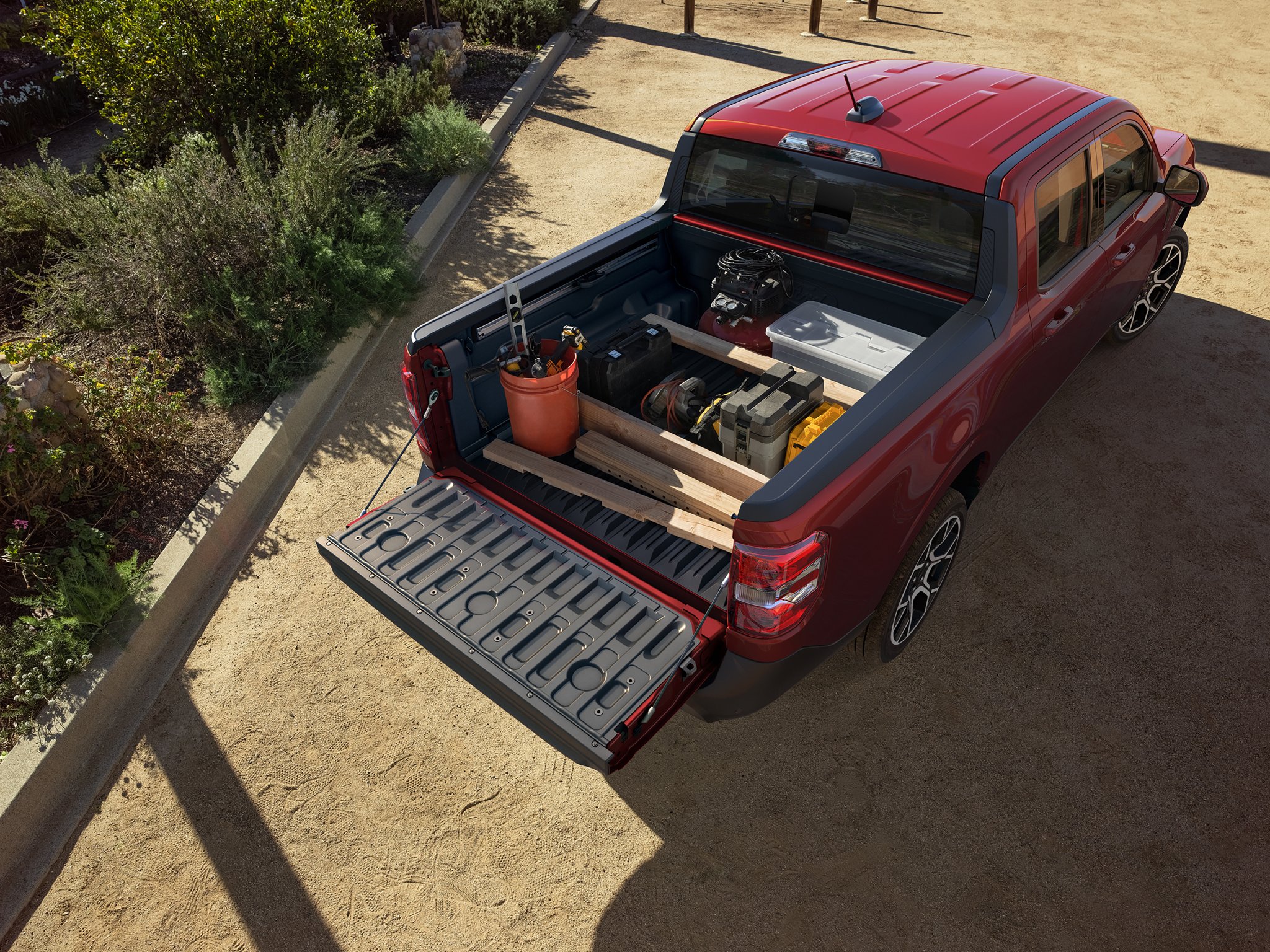 Aerial view of a 2026 Ford Maverick® truck in Ruby Red Metallic showing the FLEXBED® storage system with items in the bed 