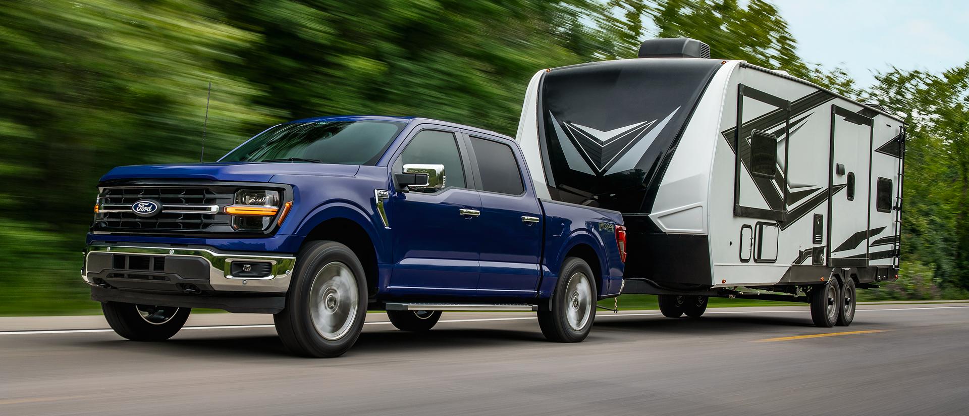 2026 Ford F-150® XL pickup in Atlas Blue Metallic pulling a camper