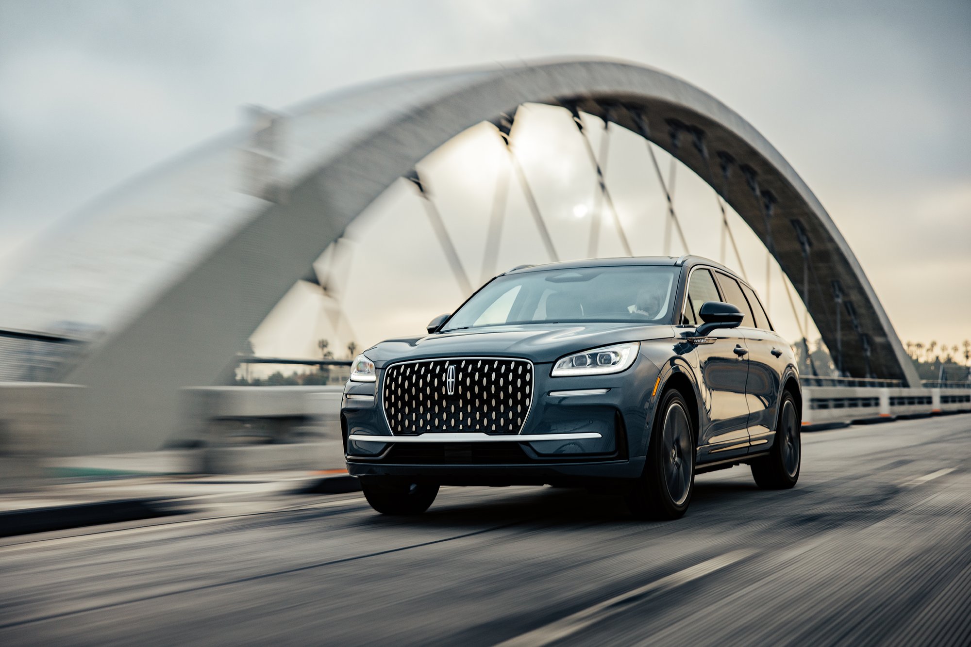 A Lincoln SUV is shown driving over a bridge.