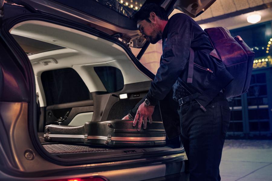 A person loads music equipment into the rear cargo are of a 2026 Lincoln Corsair SUV