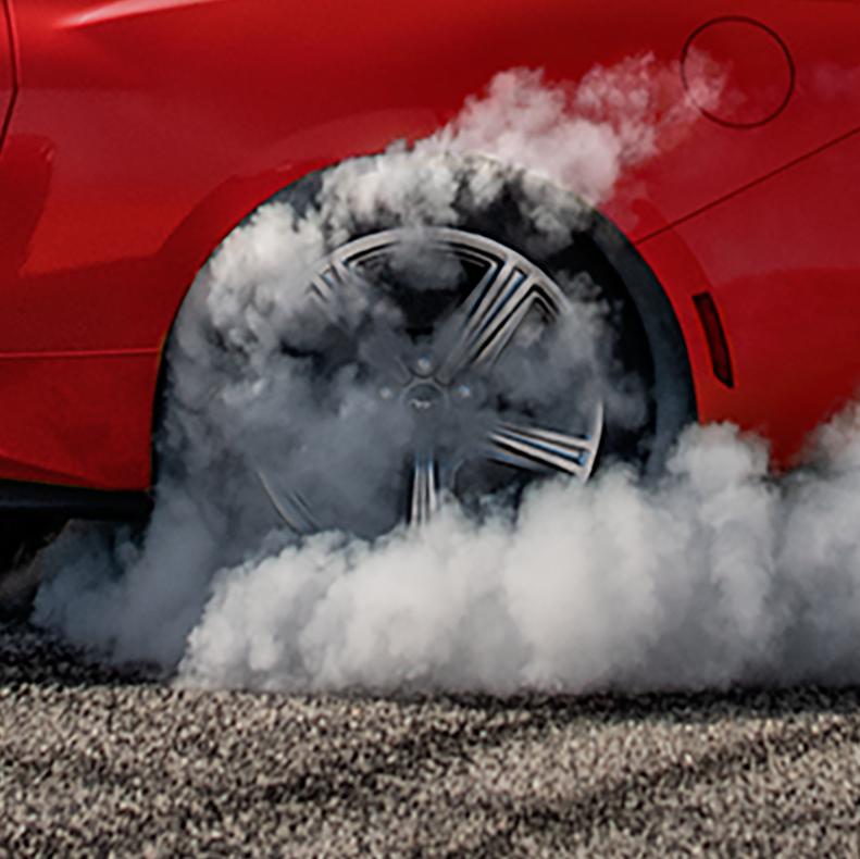 2026 Ford Mustang® EcoBoost® in Race Red spinning around with smoke coming out of back tire