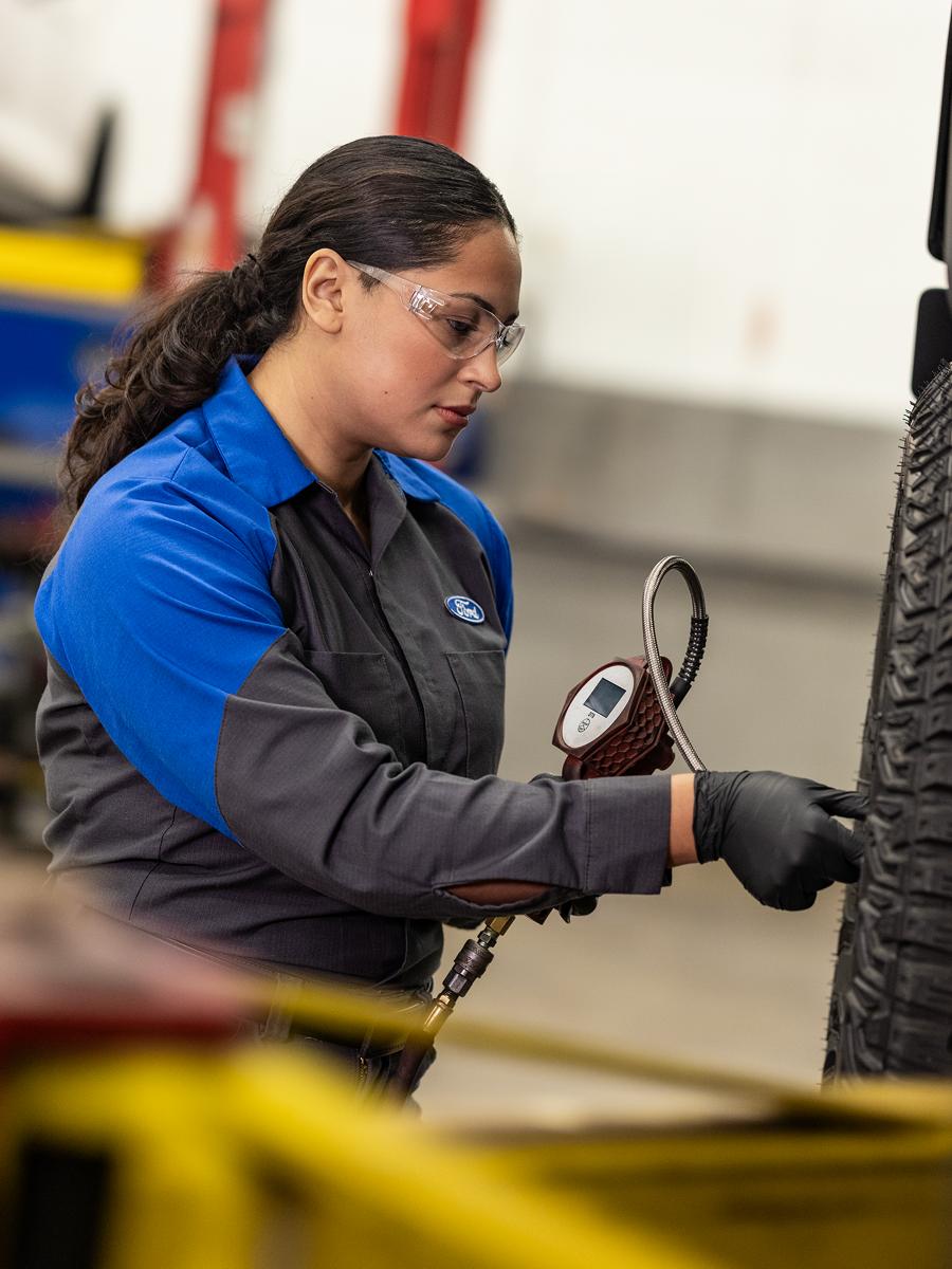 A Ford Service technician checks the pressure on a newly fitted tire