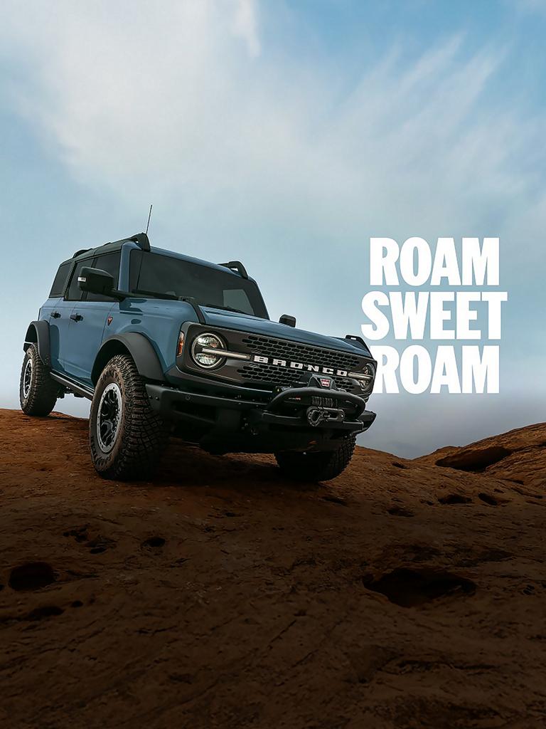 A Ford Bronco® Badlands® SUV parked triumphantly on top of a large rock formation