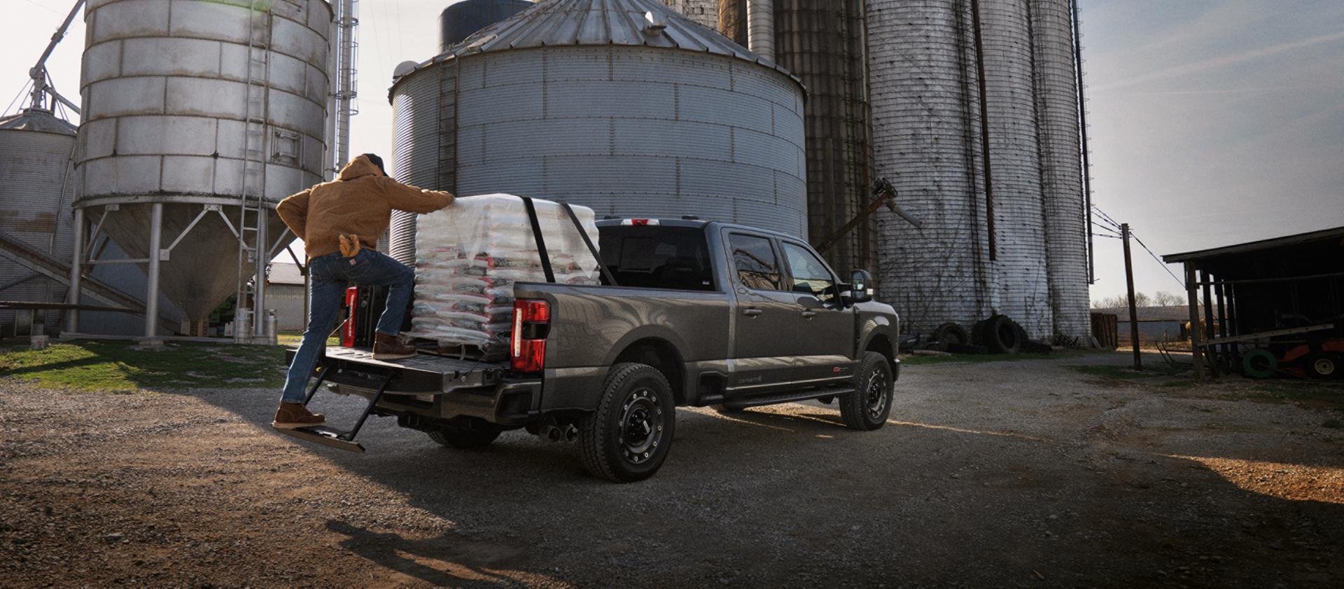 Person climbing into the bed of their 2027 Ford Super Duty® F-350® XLT model with the Super Duty Carhartt® Package