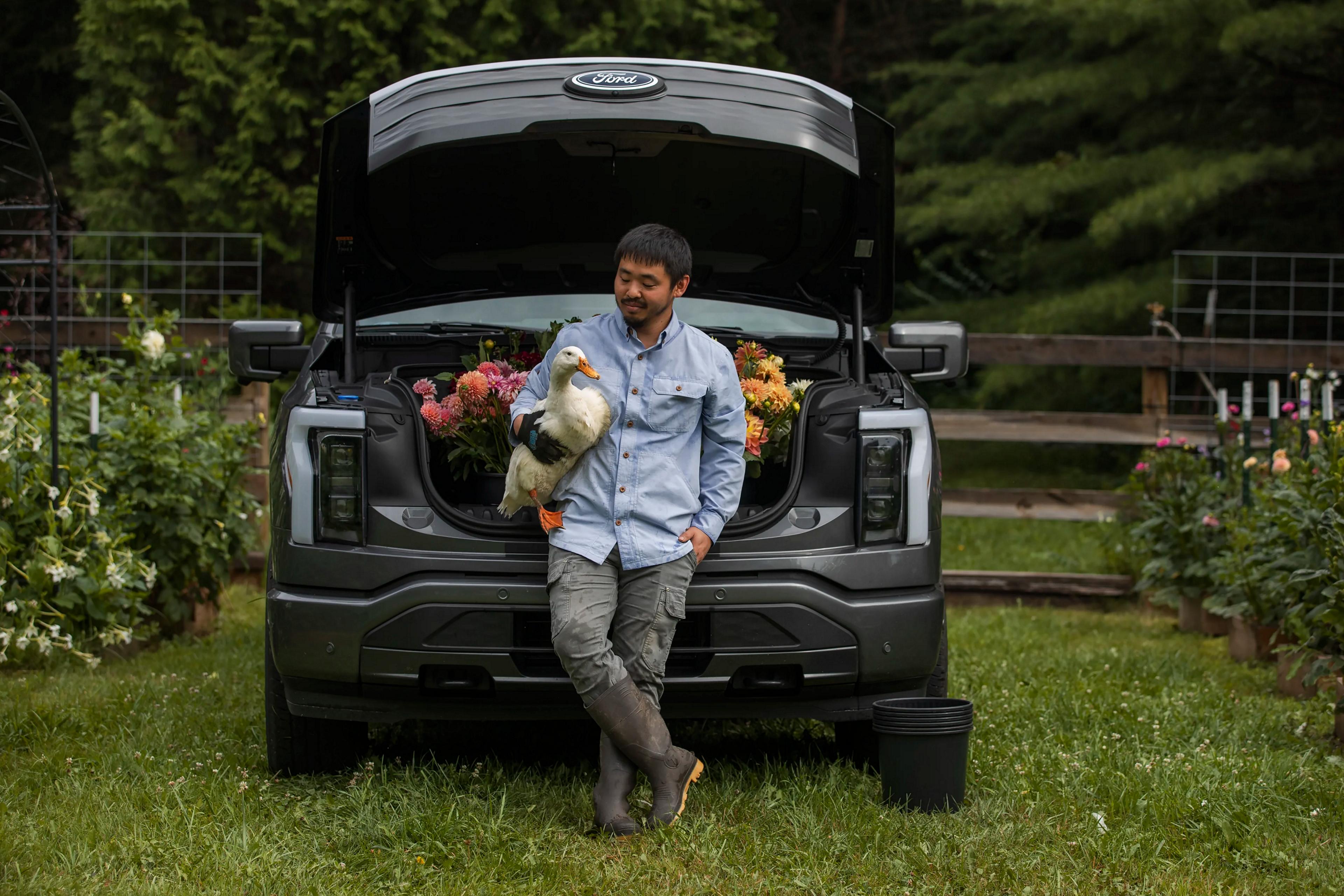 Man standing in front of his Ford F-150 Lightning while holding a duck