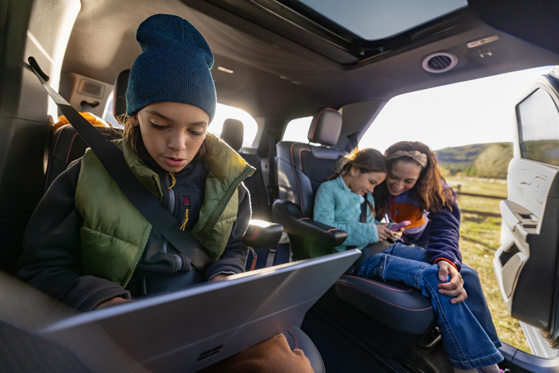 A family using their devices while seated in a parked 2026 Ford Explorer® SUV