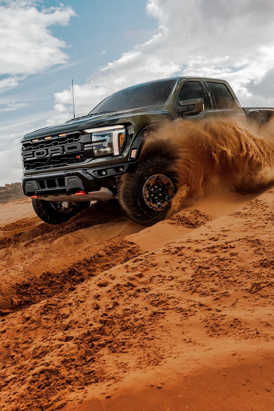 2026 Ford F-150® Raptor® truck being driven in the desert kicking a cloud of sand