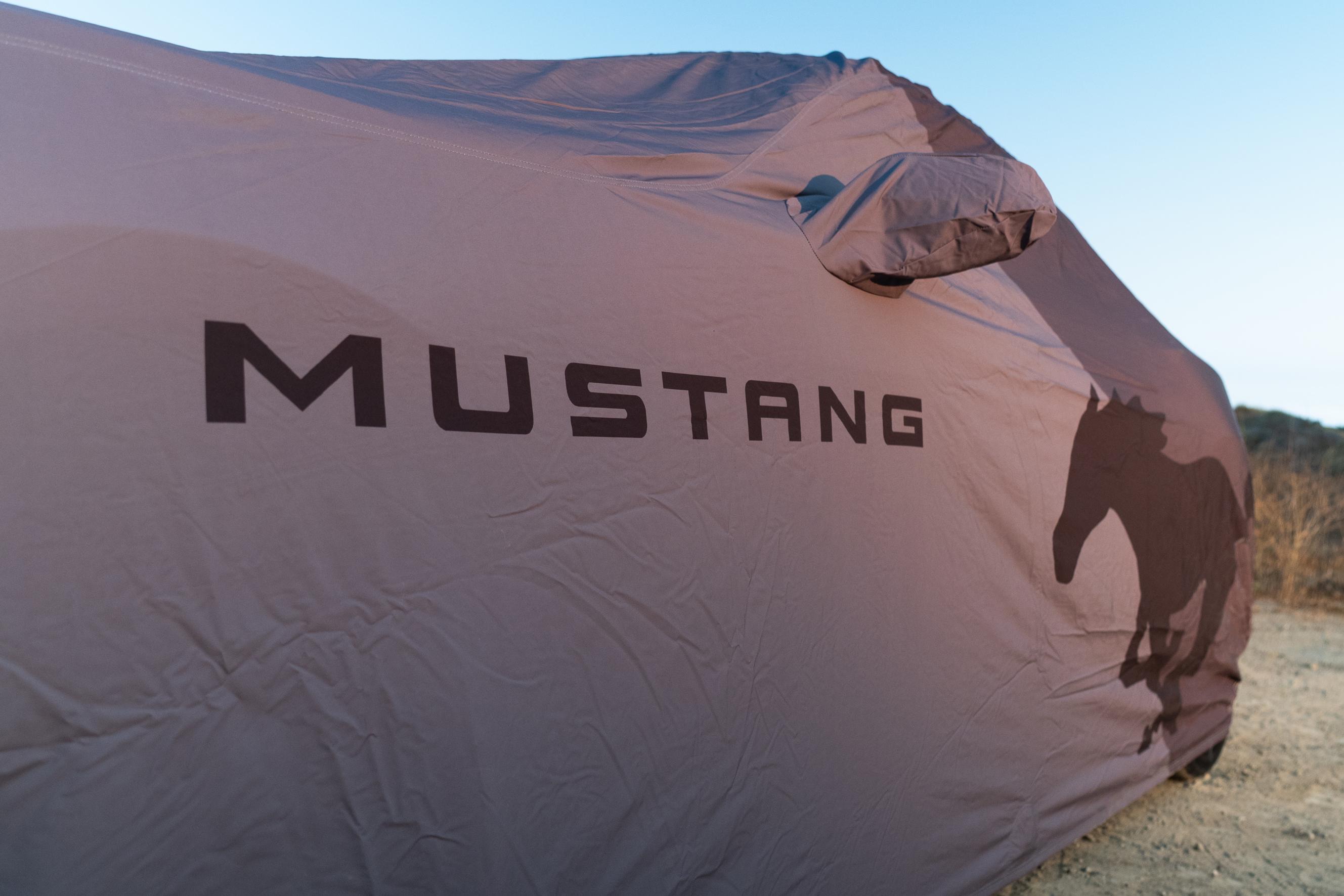 A Coverking® Mustang logo full vehicle cover wrapped around a Ford Mustang®