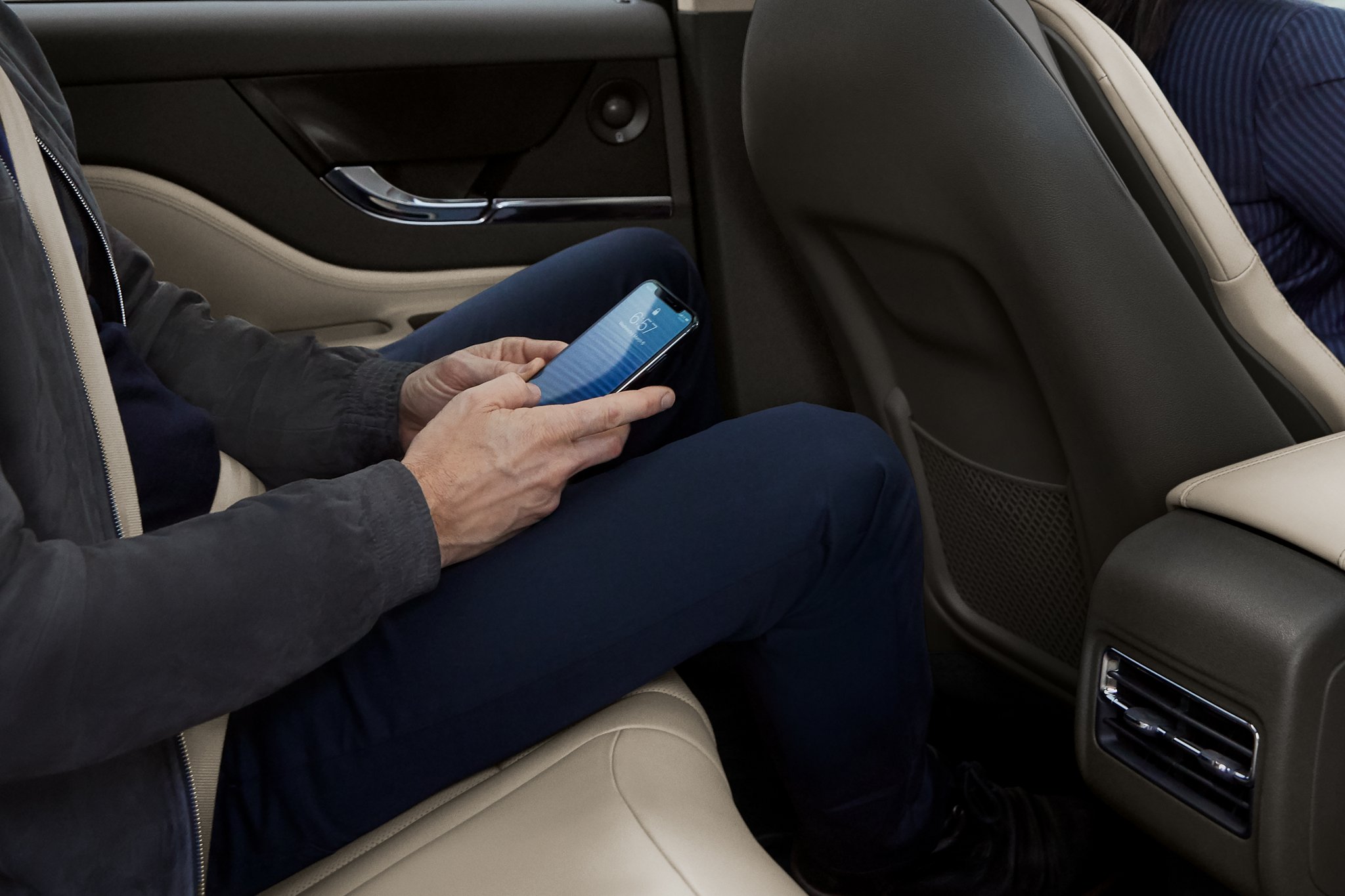 A person is shown using a mobile phone while using a 2025 Lincoln Corsair as a mobile Wi-Fi hotspot