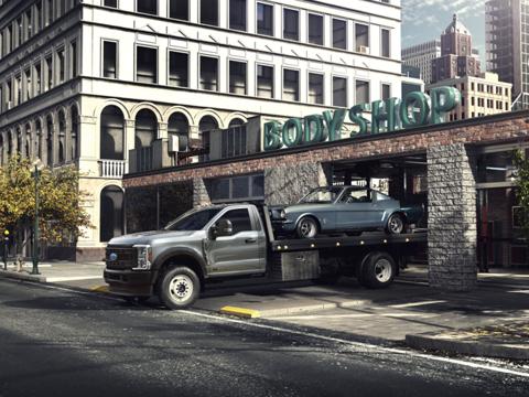 A 2024 Ford Super Duty® F-600 with a classic Mustang® on it's towing bed