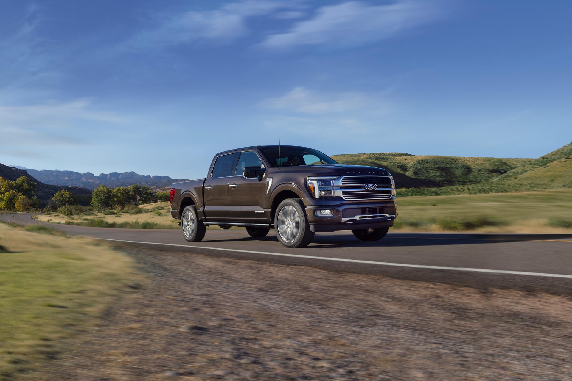 A 2024 Ford F-150® hybrid truck being driven on a road with a mountainous landscape