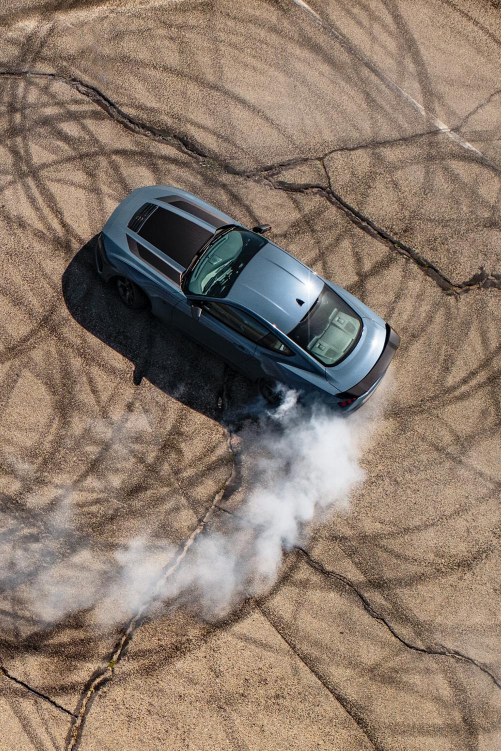 An overhead image of the 2025 Ford Mustang Dark Horse model being driven around on track pavement and making circular tire tracks