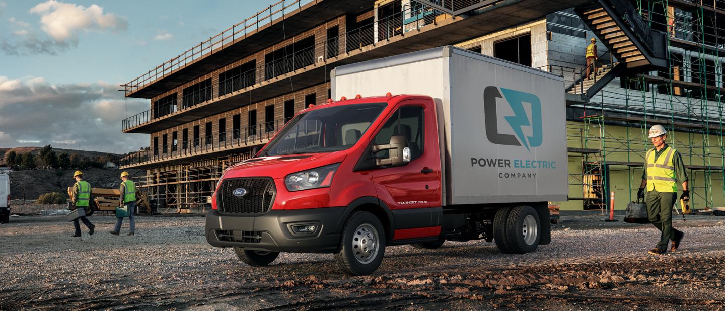 2025 Ford Transit® Chassis Cab with box truck upfit parked at a construction site with a person approaching in safety gear