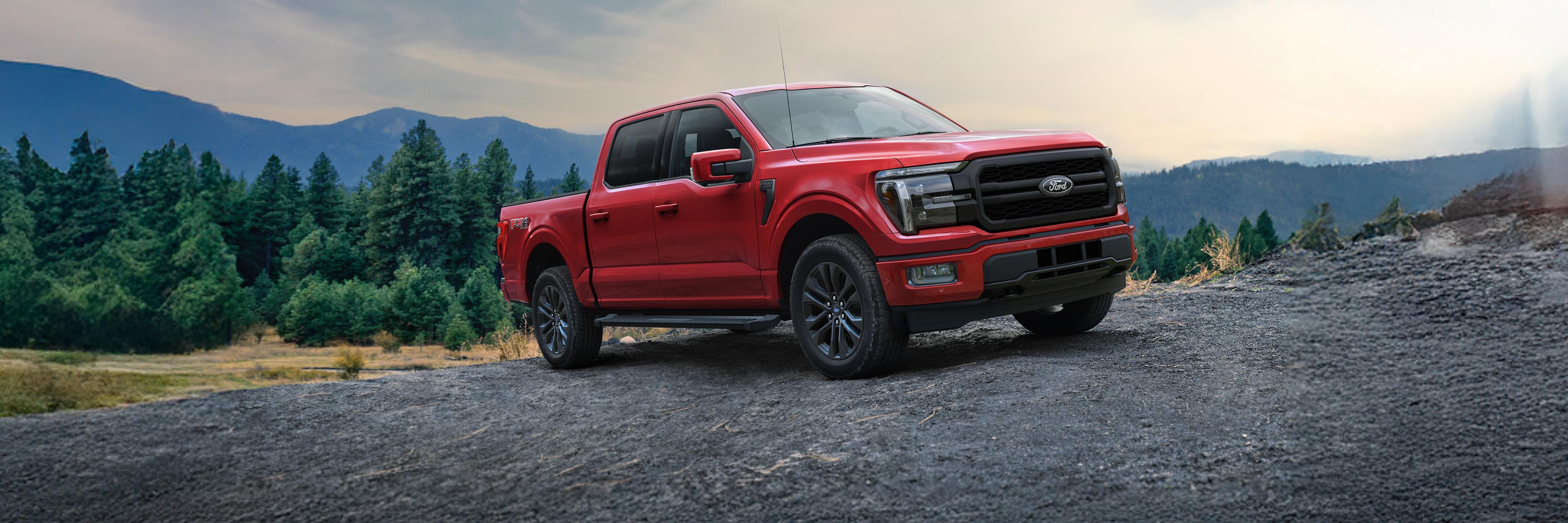A 2025 Ford F-150® Lariat® truck parked on a gravel road with mountains in the distance