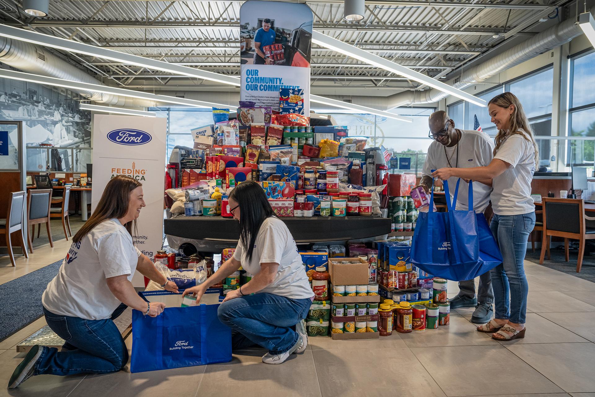A group of volunteers organizing food donations at a Ford Dealership