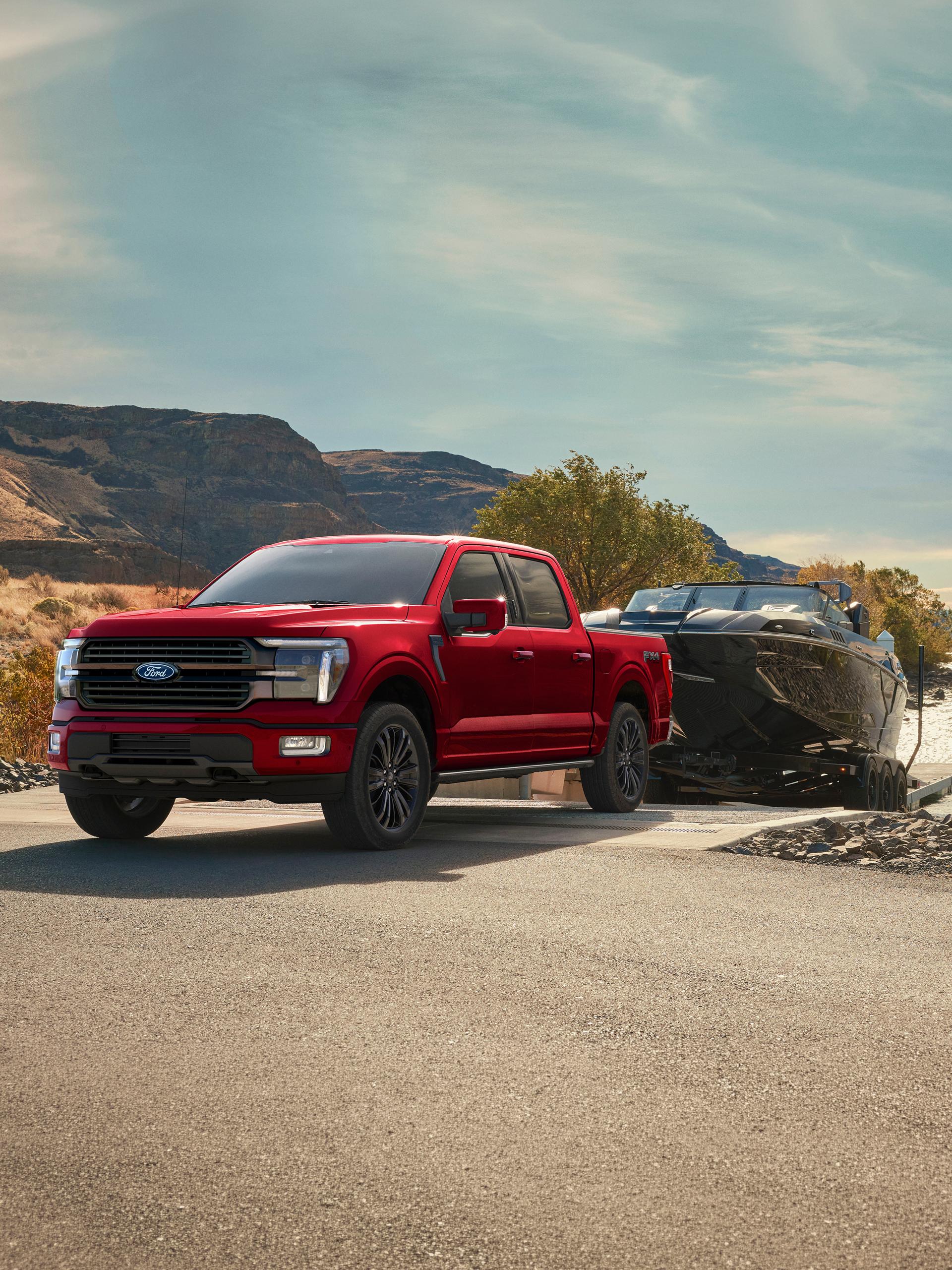 2027 Ford F-150® Platinum® truck in Ruby Red Metallic pulling a camper