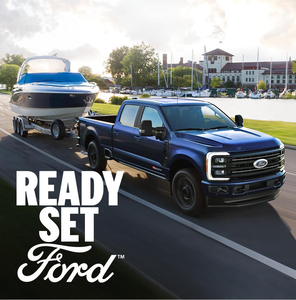 A 2026 Ford Super Duty® truck tows a boat alongside a harbor
