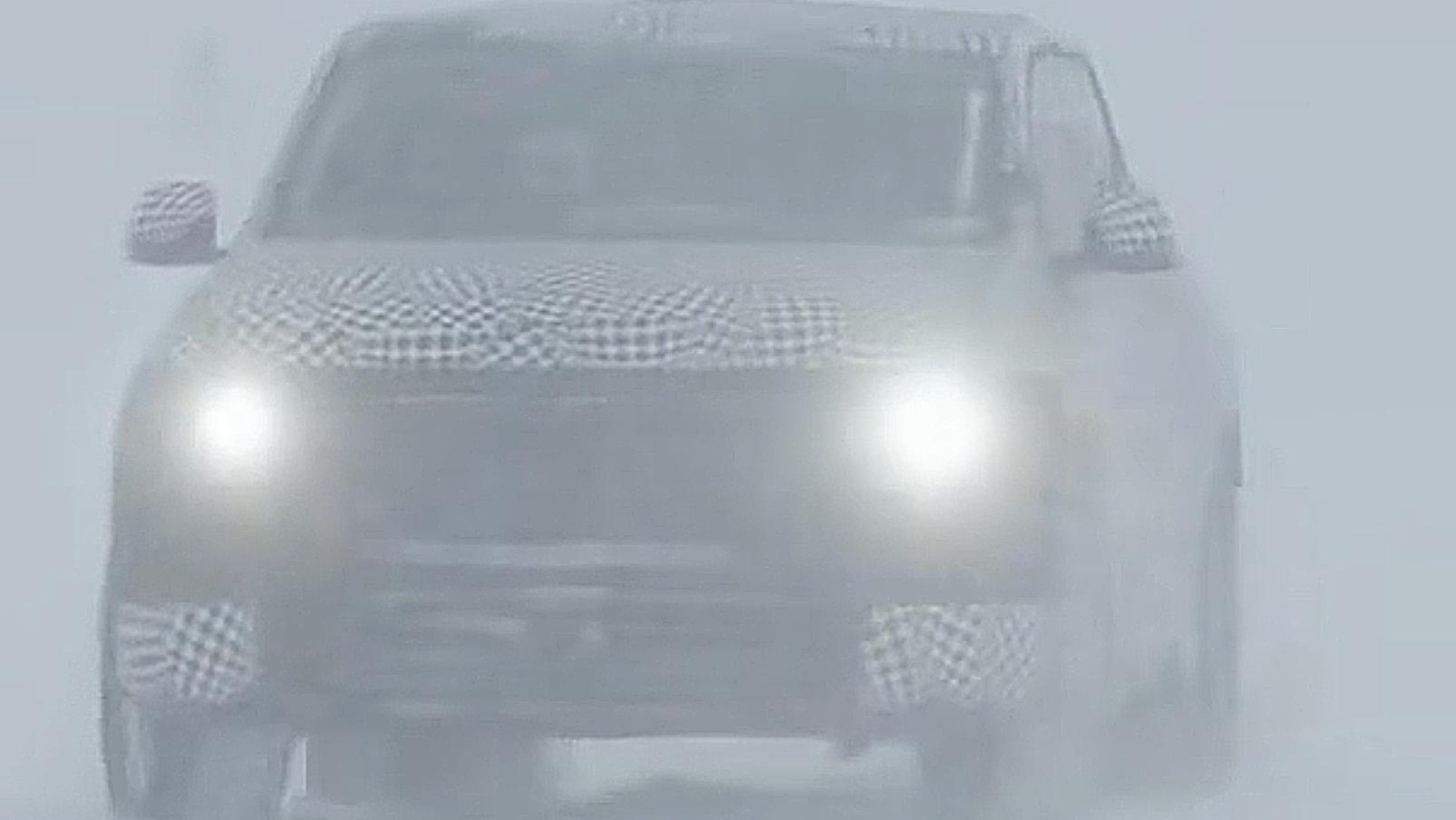 A head on shot of the truck with the headlights on driving in the snow