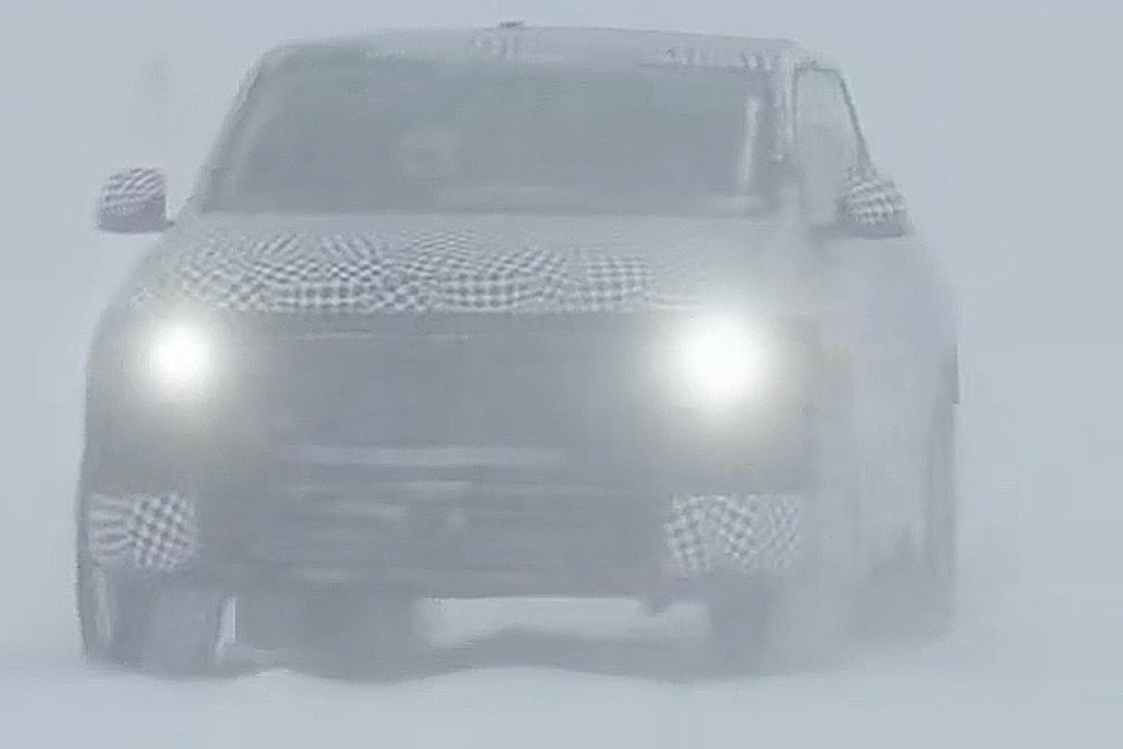 A head on shot of the truck with the headlights on driving in the snow
