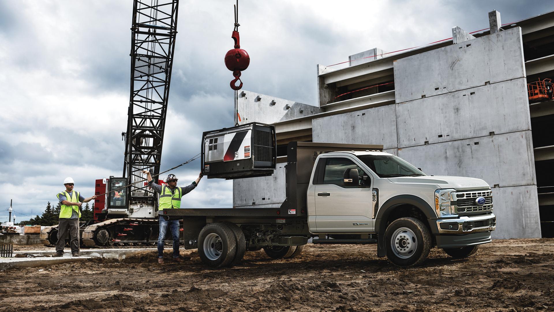 A 2026 Ford Super Duty® Chassis Cab parked on a construction site while something is being loaded onto the flatbed
