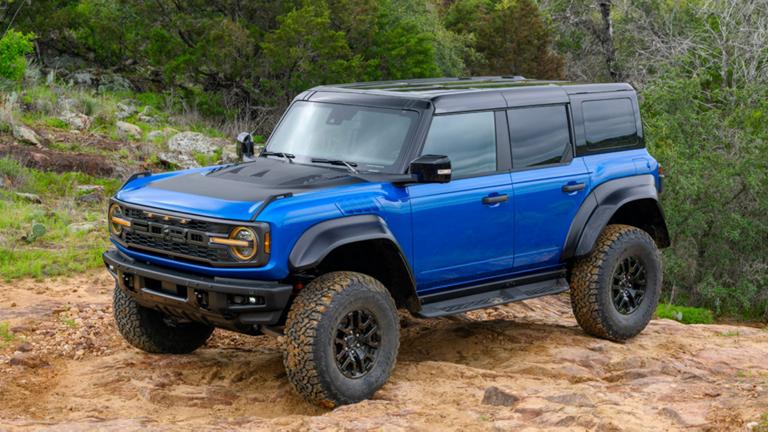 A blue 2025 Ford Bronco® Raptor® parked on a  trail, providing a clear view of its black, beadlock-capable off-road wheels