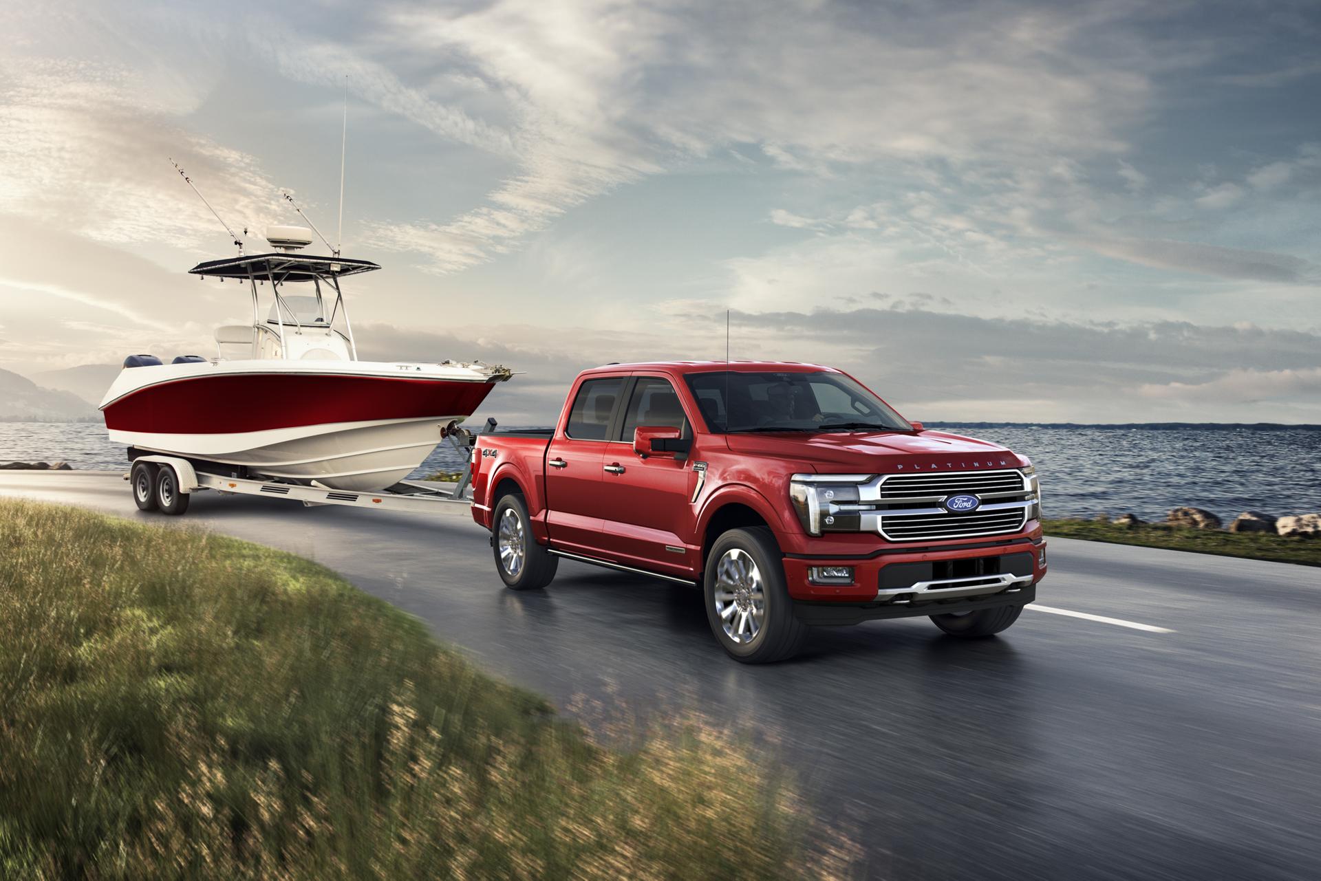 Red 2024 Ford F-150® Platinum® model truck towing a fishing boat