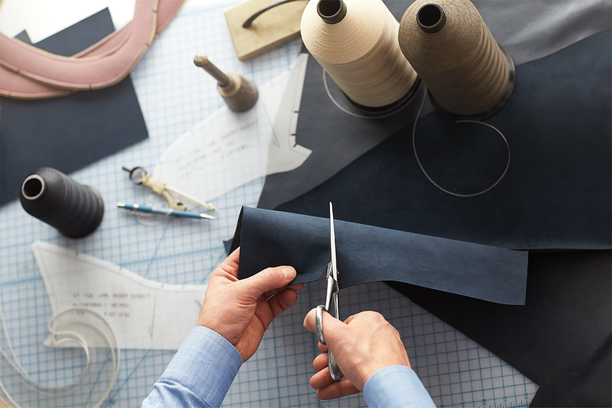 A man cutting a piece of fabric.
