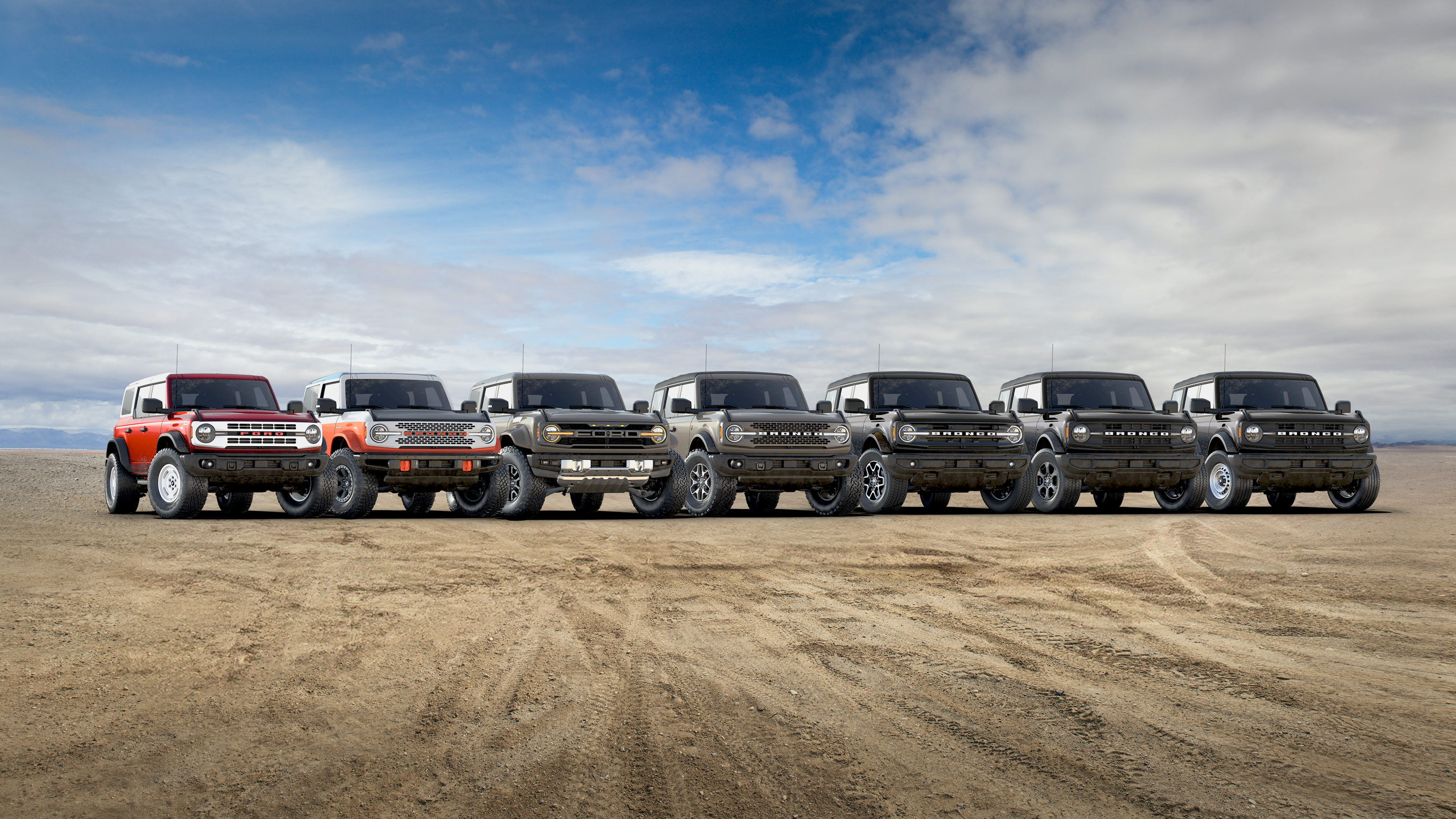 The seven 2025 Ford Bronco® models lined up next to each other on a mud flat