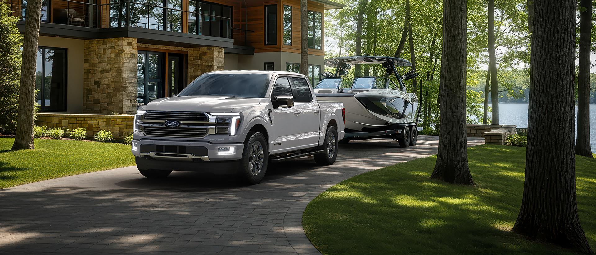 2026 Ford F-150® Platinum® model with Satin Package pulling a small trailer on a country road