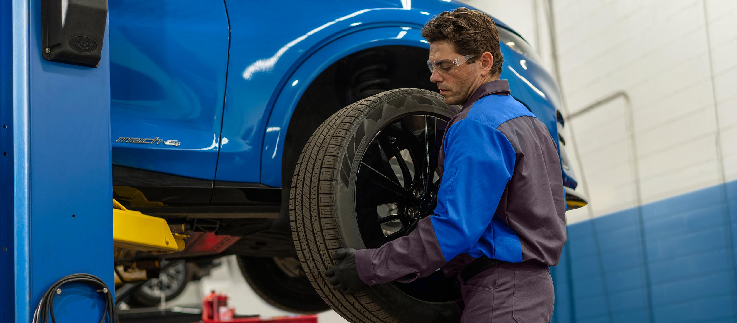 A Ford technician puts a new tire on a Ford vehicle