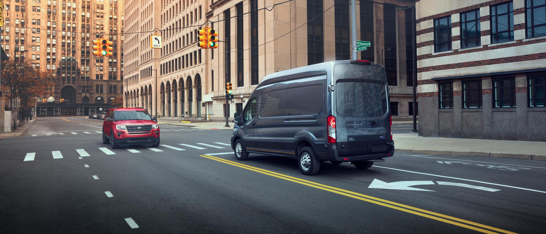 A 2025 Ford Transit® van stopped in the left-hand turn lane of an intersection
