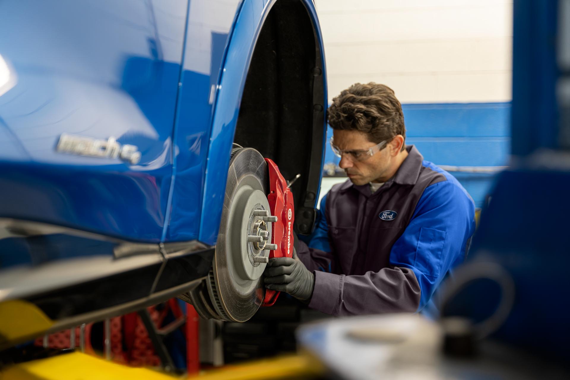 A Ford Service technician inspects the rotors on a Ford vehicle
