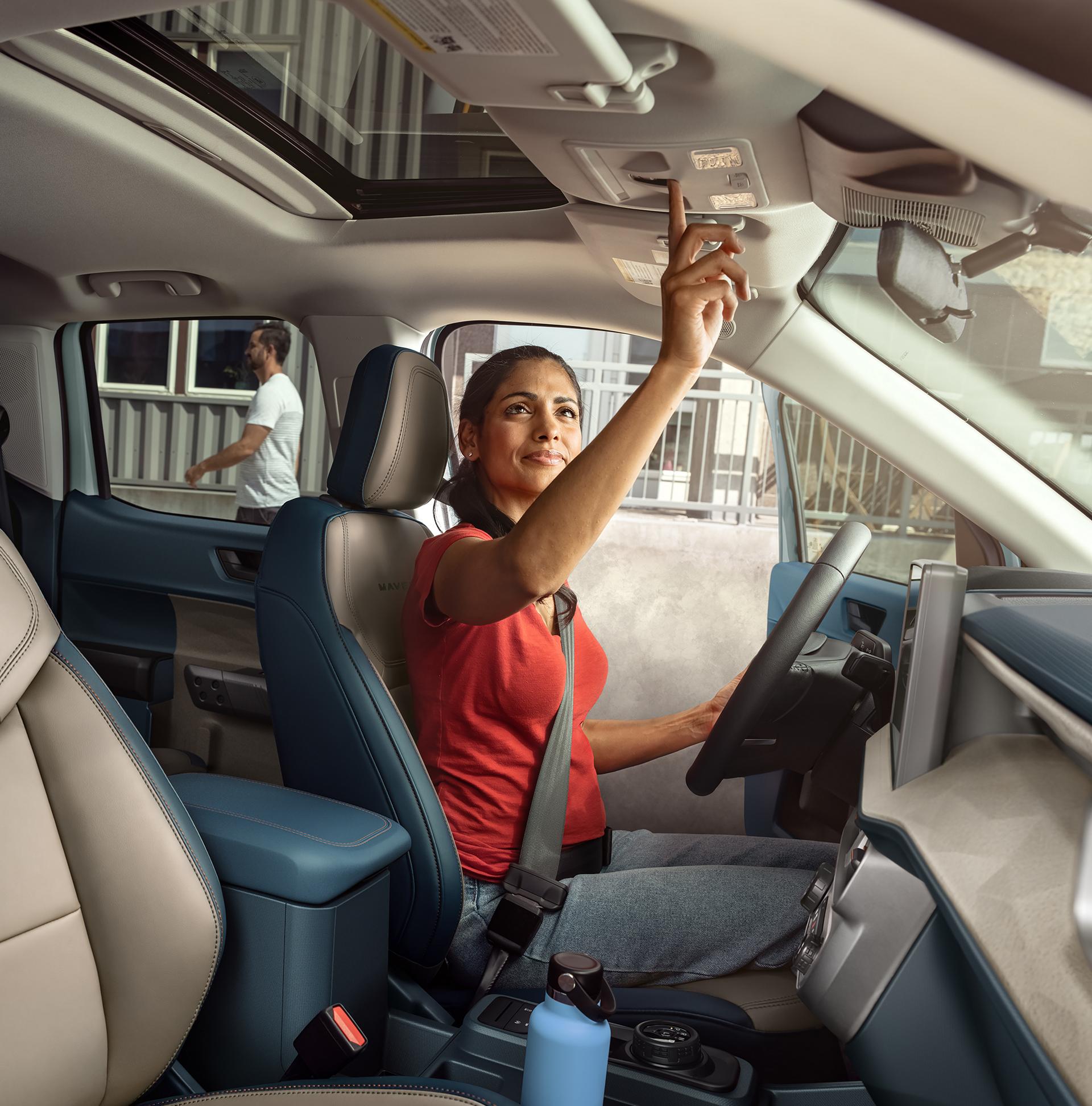 Woman using the moonroof controls of a 2026 Ford Maverick® Lariat® pickup