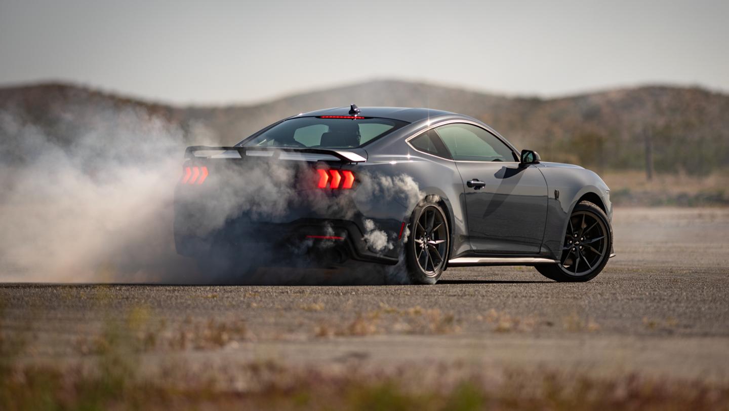 2025 Ford Mustang® Dark Horse™ coupe in Vapor Blue Metallic with a driver performing burnouts on a closed course