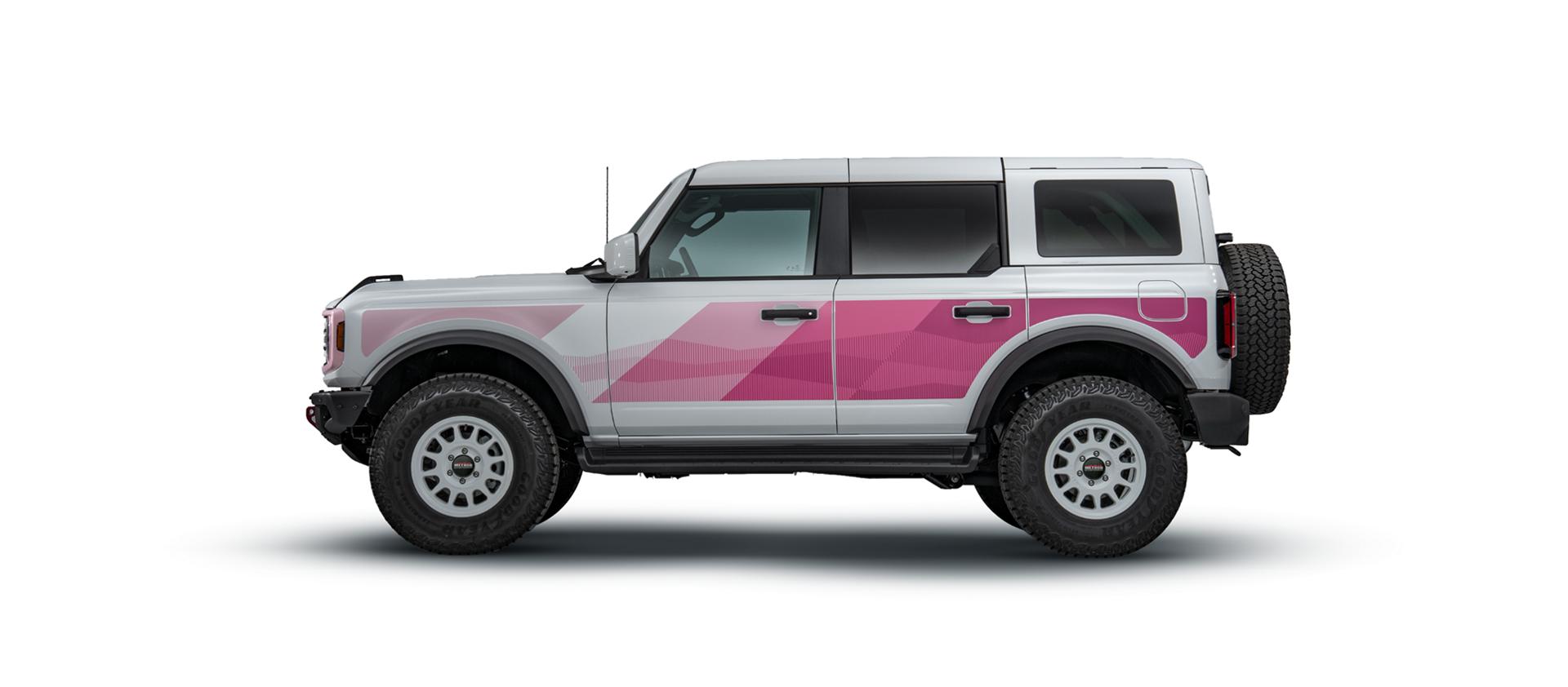 Driver-side profile of the white Bronco with pink bodyside graphics