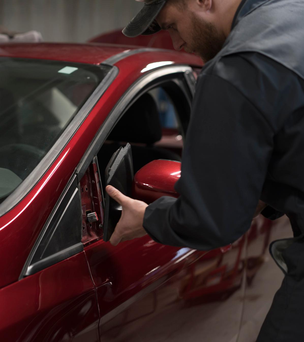 A Ford technician replaces a sideview mirror