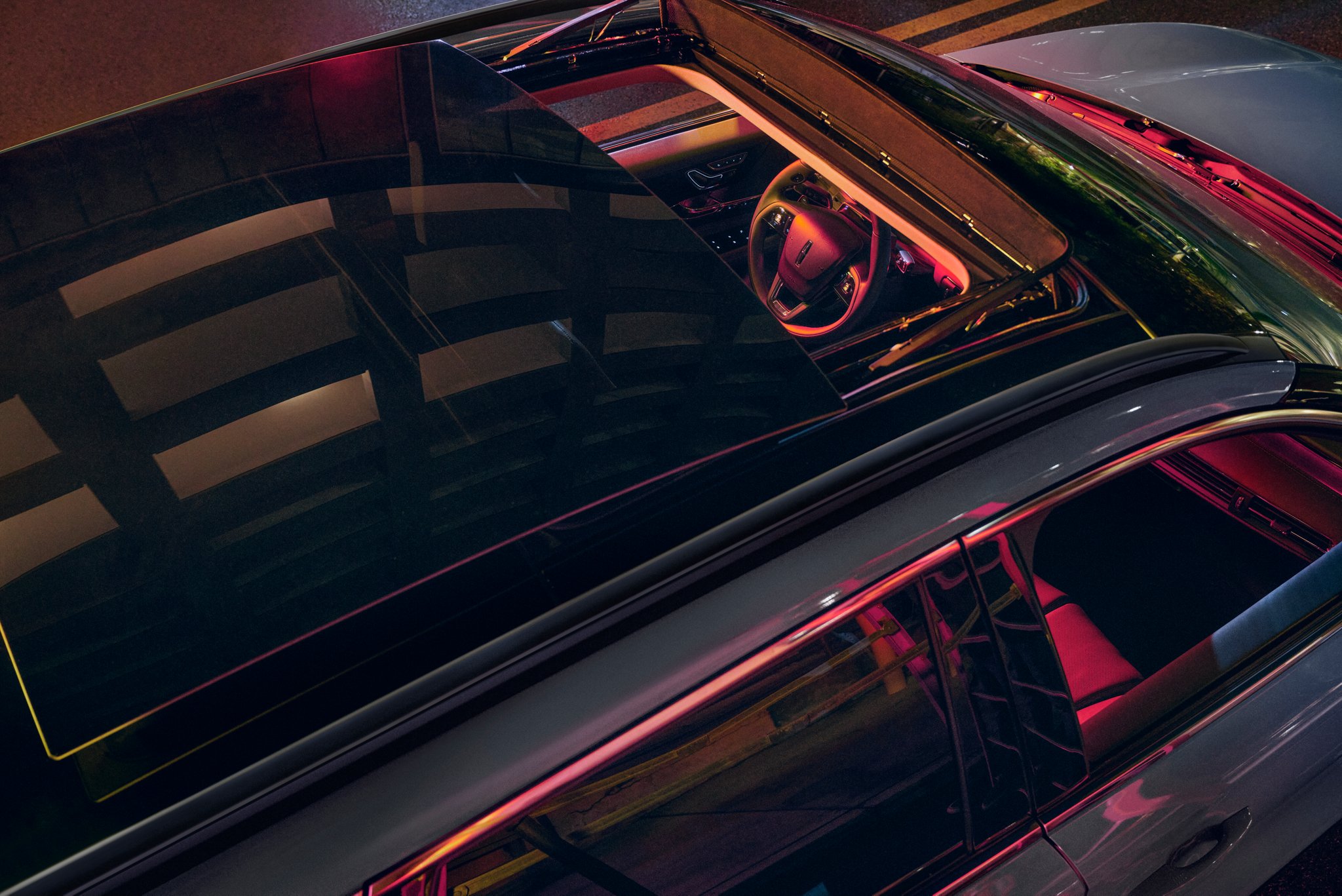 Neon light pours through the available panoramic Vista Roof® of a 2026 Lincoln Corsair® Reserve model