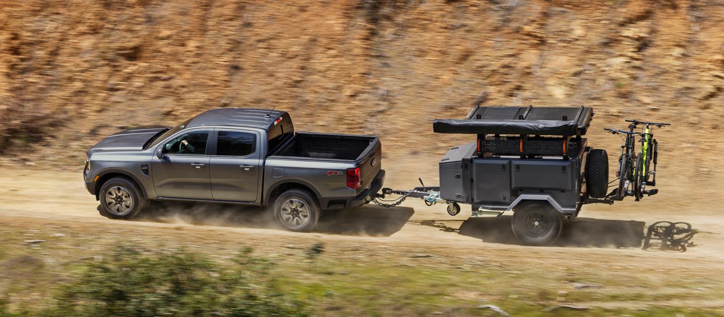 2026 Ford Ranger® Lariat® model towing a trailer on a dirt mountain road