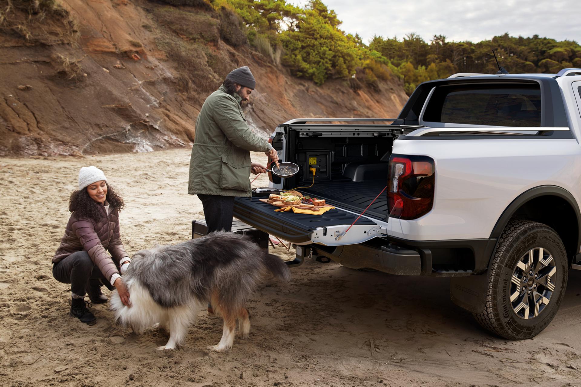 A Ford truck owner uses the tailgate to serve up breakfast on the beach for their partner and dog