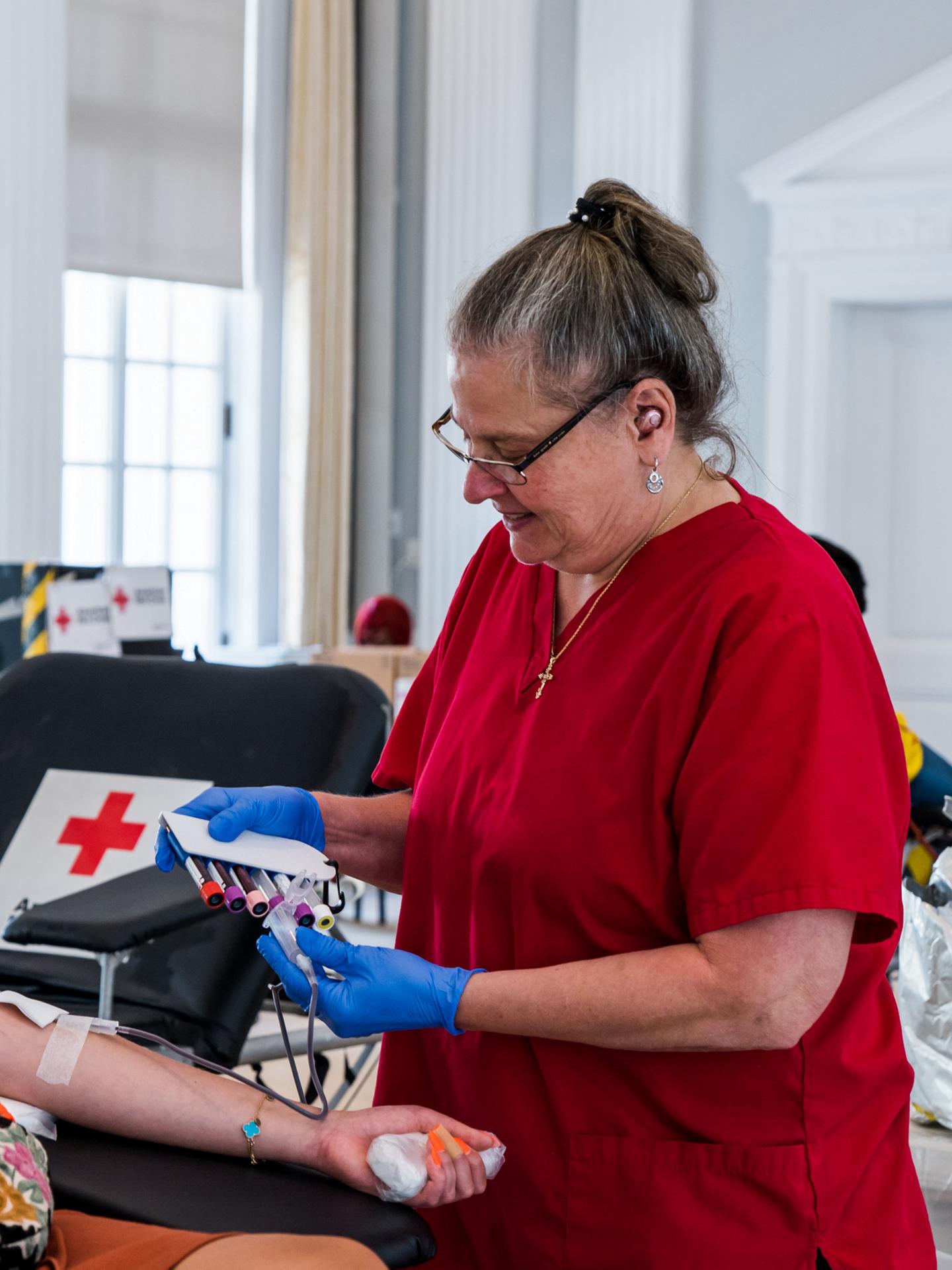 A worker at a blood bank holding a bag
