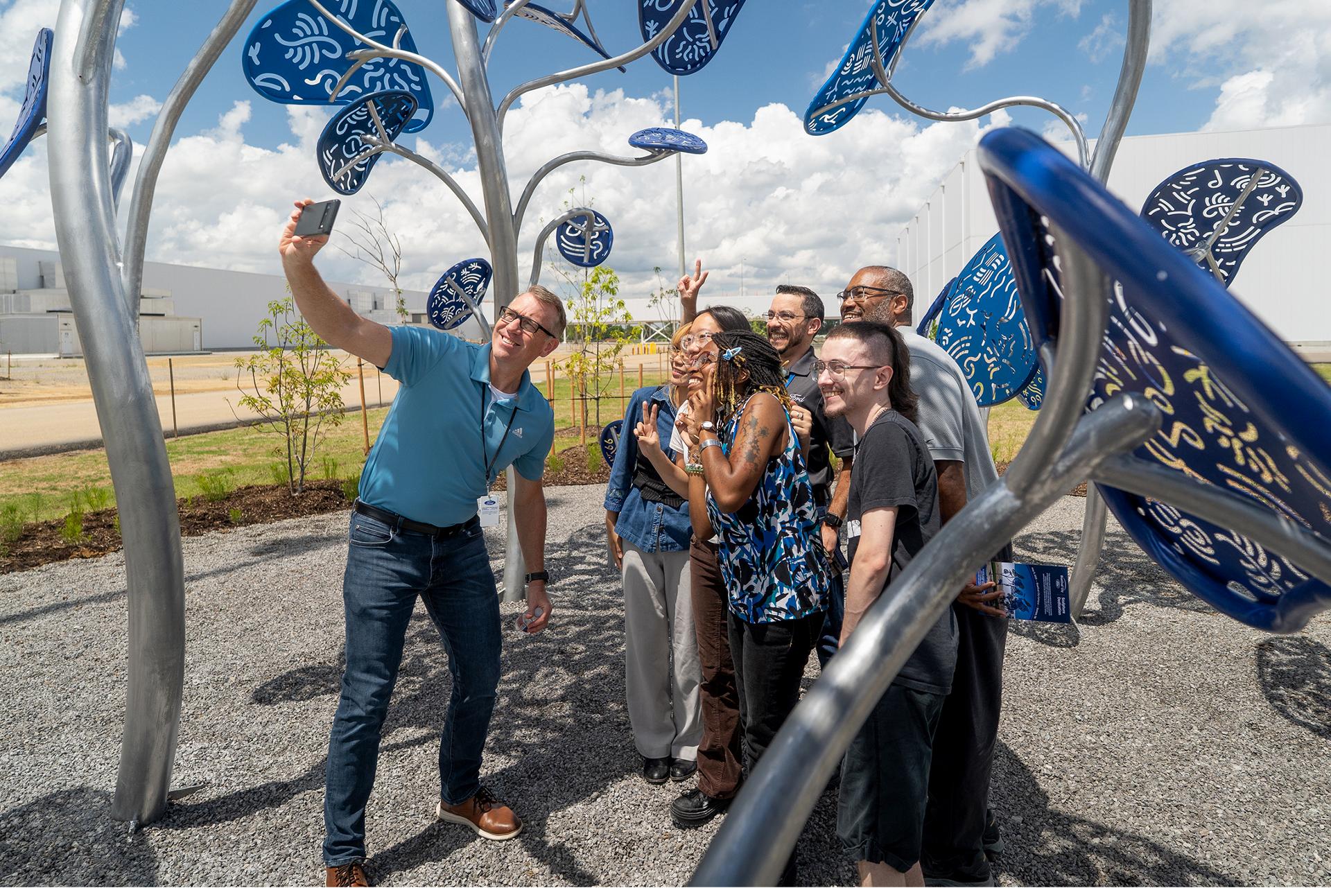 Students standing near the statue they designed at the entrance of the Tennessee Truck Plant