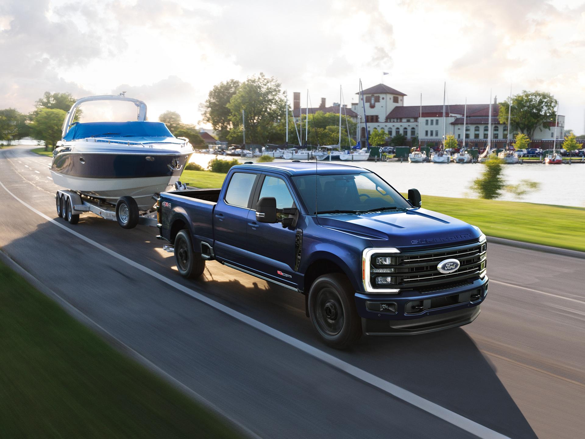 Modelo Ford Super Duty® F-350® Platinum® 2027 remolcando una lancha en un camino pavimentado
