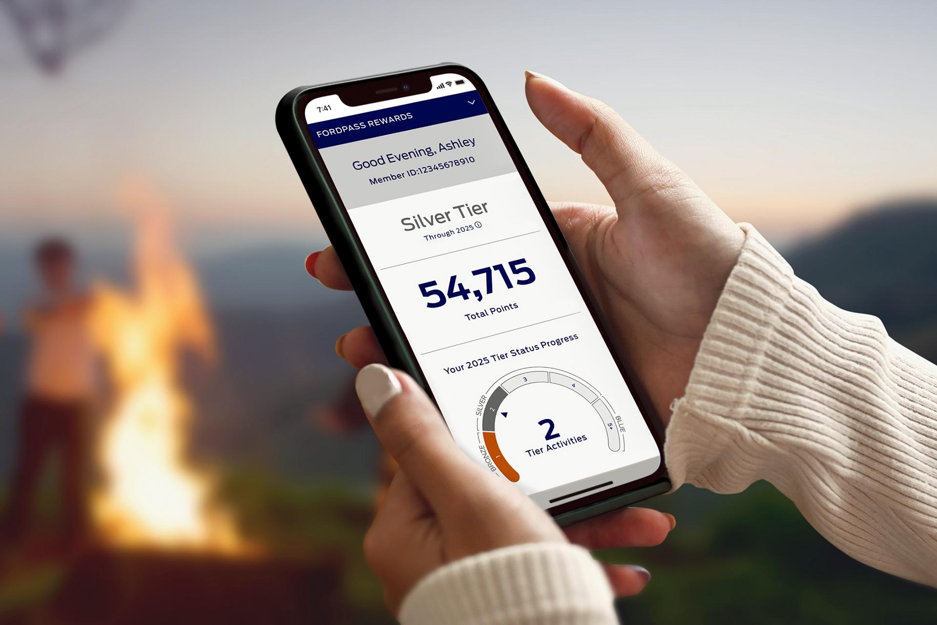 Person holding a phone displaying Ford Rewards points