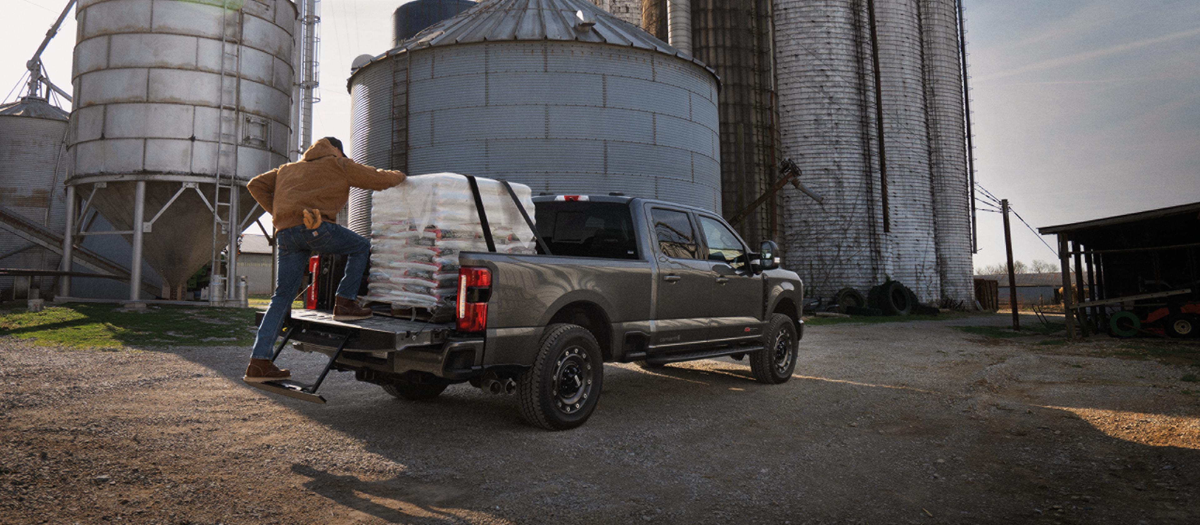 Person climbing into the bed of their 2027 Ford Super Duty® F-350® XLT model with the Super Duty Carhartt® Package