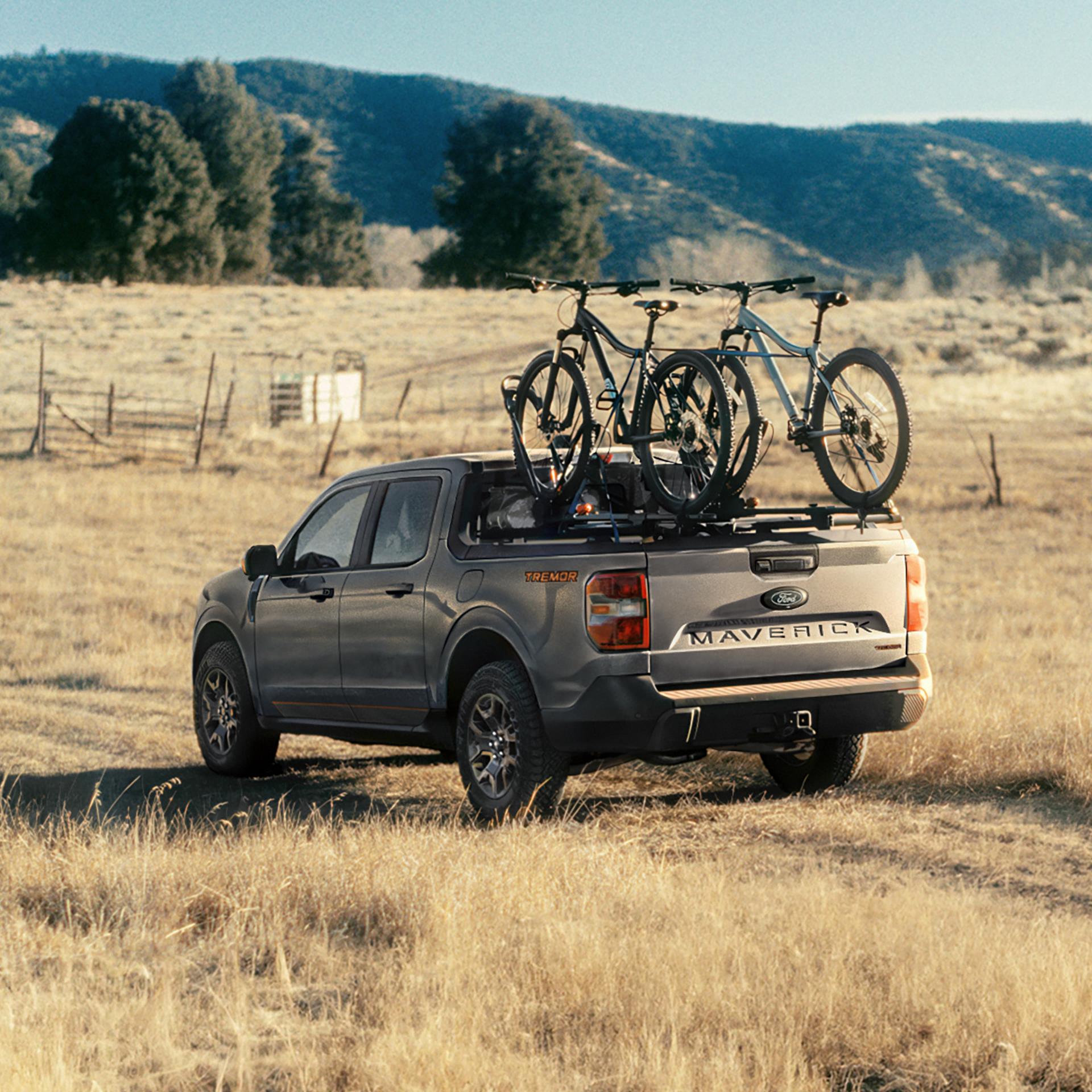 2026 Ford Maverick® Tremor® model being driven on a grassy field with bikes mounted in the bed