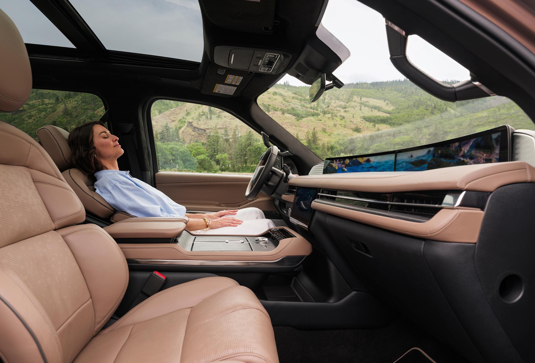 A woman sitting inside a parked Lincoln Navigator, with the exterior of the car visible.