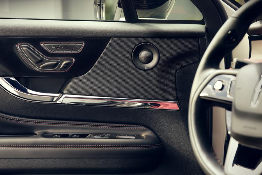 A mid-range speaker of the available 14-speaker Revel Audio System is shown in the driver's front door panel