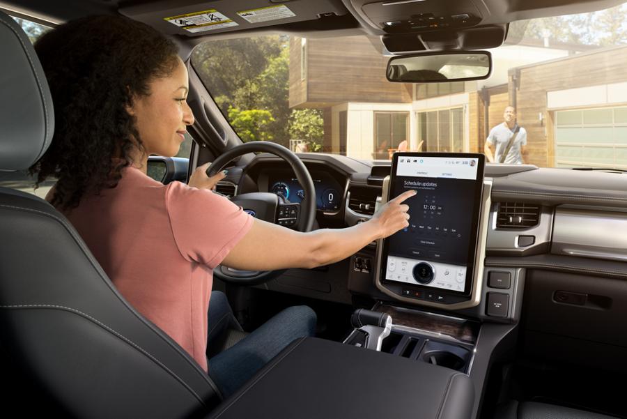 Driver using the large touchscreen inside the Ford F-150 Lightning®